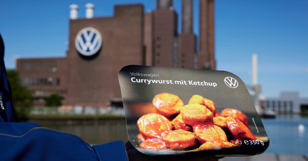 Volkswagen Currywurst mit Ketchup i bakgrunnen av fabrikken